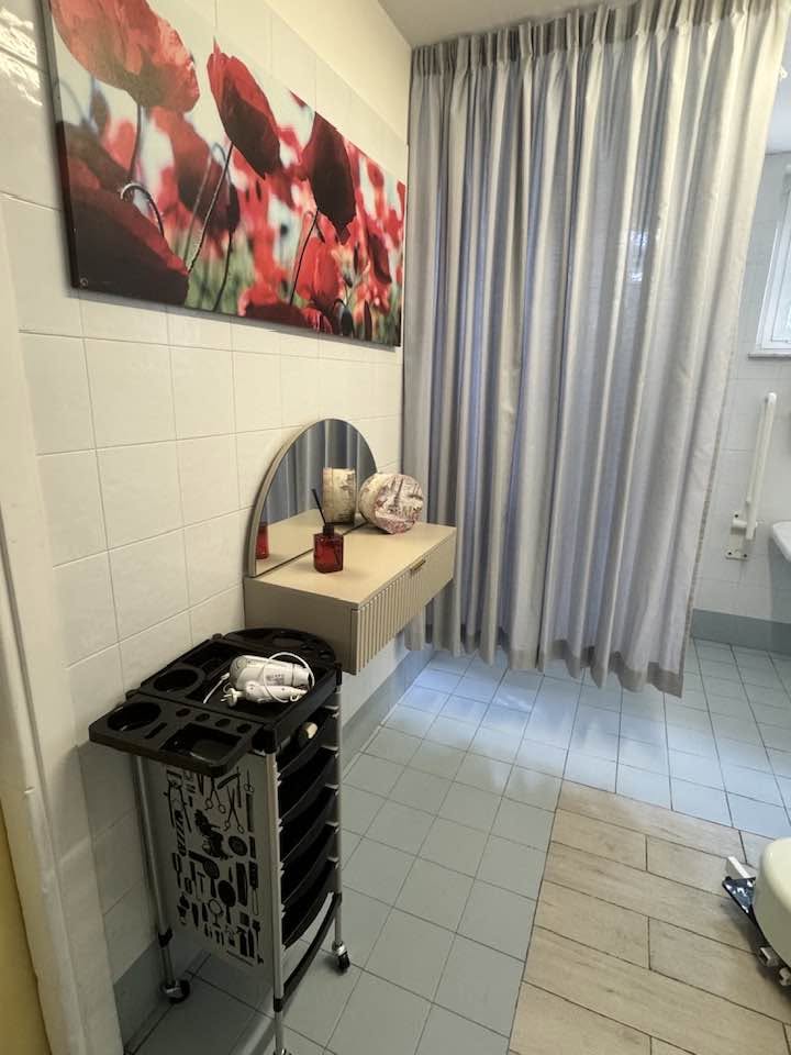 Postazione della stanza benessere con specchio, mobile e attrezzatura per la cura della persona